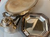 a silver tray with a mirror and a silver plate with a bird on it