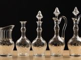 four clear glass vases sitting next to each other on a wooden table