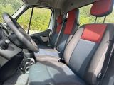 the interior of a van with red and grey seats and a steering wheel