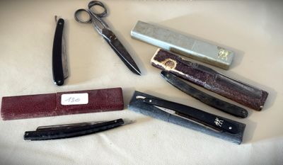 de nombreux types de ciseaux et de rasoirs disposés sur une table