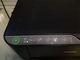 a close up of a printer with a green button on it