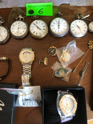 une table sur laquelle sont posées de nombreuses montres et d'autres objets