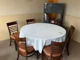 une table et des chaises blanches dans une pièce avec une cheminée