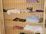an image of a closet with clothes on the shelves