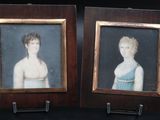 two framed portraits of a boy and a girl in a blue dress
