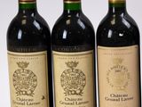 trois bouteilles de vin sont alignées sur une surface blanche