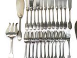many spoons and forks laid out on a white surface