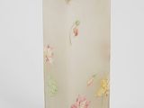 a glass vase with flowers on it on a white surface