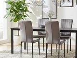 a dining room table with chairs and a plant in the corner