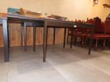 a table and chairs in a room with wood paneled walls