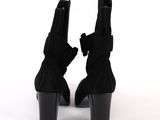 pair of black sued ankle boots with bows on the heel