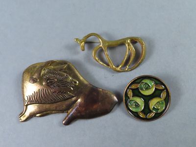 une broche en or ornée d'un oiseau, à côté d'un bol rempli de fleurs