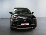 the front view of a black car parked in a showroom