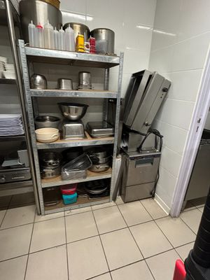 shelves with pots and pans on them in a commercial kitchen