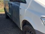 the white van is parked on the gravel in the parking lot