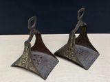 pair of antique brass bells on a wooden table