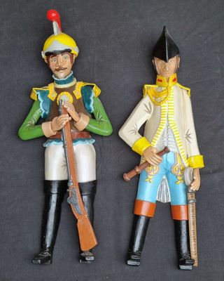 two figurines of soldiers that are standing next to each other