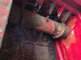 a red truck with hay on the back of it ' s bed
