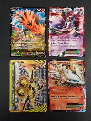 quatre cartes Pokémon différentes posées sur une table