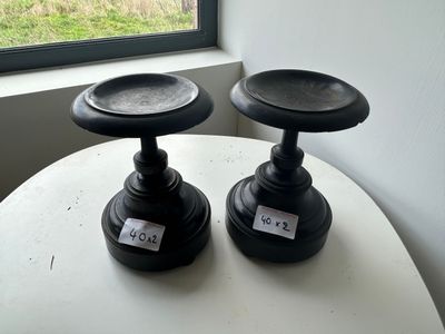 two black candlesticks sitting on a table near a window