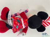 mickey mouse plush toy laying on its side on a white surface