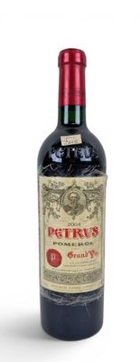 a bottle of red wine sitting on a white surface