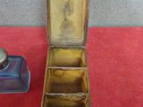 a small metal box with a lid on a red table
