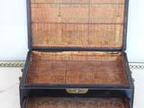 a black suitcase with a wooden lid on a white floor