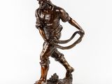 a bronze statue of a man holding a bow and arrow