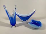 two blue glass bowls and a spoon on a table