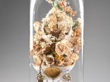 a glass clochet with a bunch of flowers inside of it