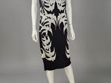 a black and white dress with gold embroidery on the shoulders