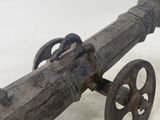an old wooden cannon on wheels on a white surface