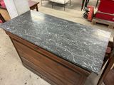 a marble counter top on a wooden cabinet in a store