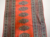 a red and blue rug on a white surface