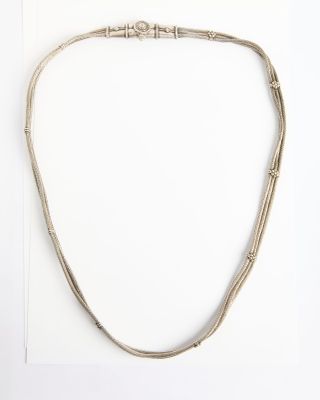 un collier en argent composé de trois brins de fil d'argent sur fond blanc