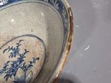 a blue and white bowl with a flower design on it