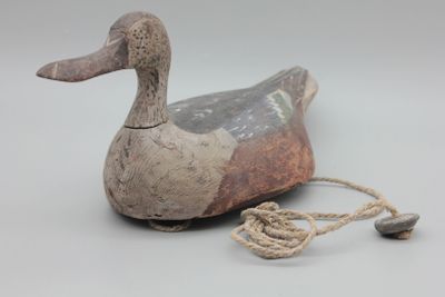un petit canard en bois auquel est attachée une corde