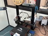 une imprimante 3D posée sur une table en bois