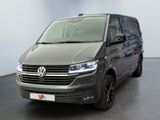 La camionnette grise est garée dans une grande pièce au sol noir.