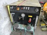 a machine that is sitting on the ground next to a wall