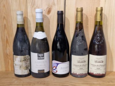 several bottles of wine are lined up on a shelf in front of a wooden wall