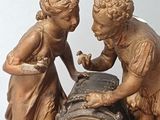 two figurines of a boy and a girl with a clock on a table