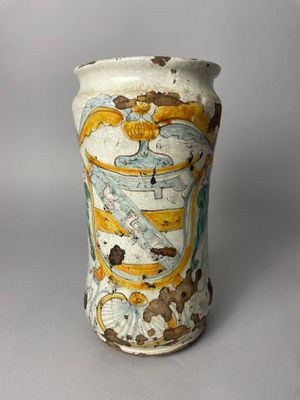un vase blanc orné d'un motif jaune et bleu