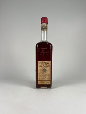 une bouteille d'alcool vide posée sur une surface blanche
