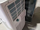 a white air conditioner sitting on the floor next to a box