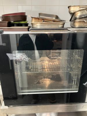 a person standing in front of an oven in a kitchen