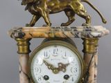 a statue of a lion standing on top of a clock