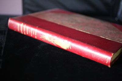 un livre rouge posé sur une table noire