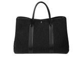 a black tote bag sitting on top of a white surface